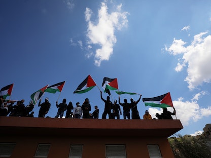 فلسطينيو الداخل الإسرائيلي يرفعون علم فلسطين في بلدة أم الفحم، 16 مارس 2021 - REUTERS