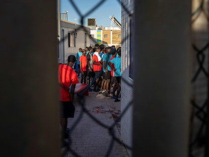 مهاجرون يصطفون في مركز مؤقت للمهاجرين وطالبي اللجوء في مليلية - 25 يونيو 2022 - AFP