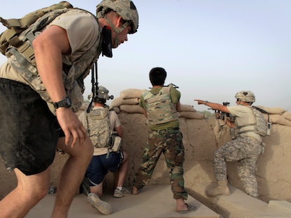 جنود من القوات الأفغانية مع كتيبة المدفعية التابعة للجيش الأميركي في أفغانستان في موقع قتالي شمال قندهار. يوليو 2010 - REUTERS