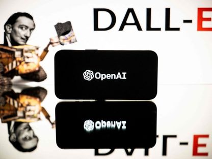 علامة شركة OpenAI التجارية تظهر على شاشة هاتف وفي الخلفية اسم نموذجها الذكي لتصميم الصور من الأوامر النصية DALL-E المتطور - AFP - AFP