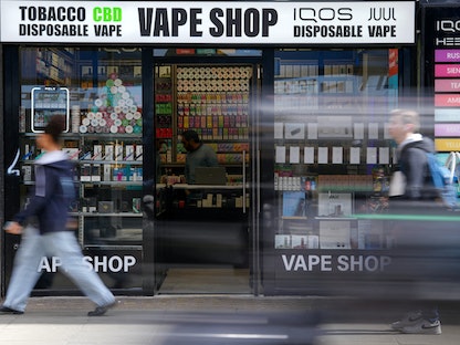 أشخاص يسيرون قرب متجر لبيع السجائر الإلكترونية وسط العاصمة البريطانية لندن. 11 أبريل 2023 - REUTERS