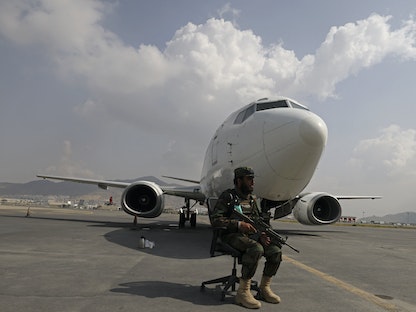 مقاتل من طالبان يجلس أمام طائرة على مدرج مطار كابول - 12 سبتمبر 2021 - AFP
