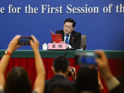 وزير الخارجية الصيني تشين جانج يحمل نسخة من الدستور الصيني في مؤتمر صحافي على هامش المؤتمر السنوي لمجلس الشعب الصيني، بكين. 7 مارس 2023 - AFP