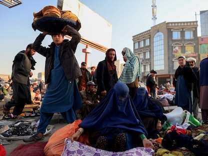 بائعة ملابس مستعملة تعرض بضاعتها بسوق شاوك في كابول- 14 أكتوبر 2021 - REUTERS