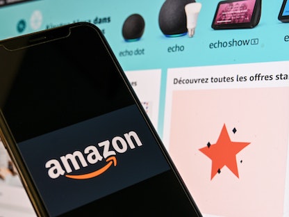 شعار أمازون أمام شاشة كمبيوتر تعرض الصفحة الرئيسية للموقع في فرنسا. - AFP