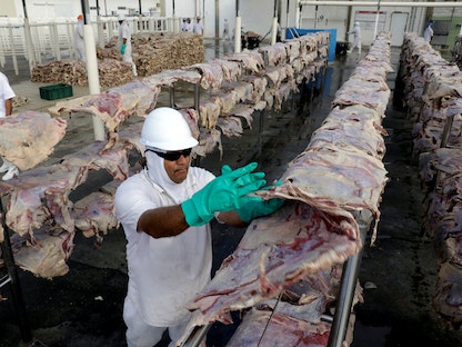 عامل في مصنع "جي بي إس" للحوم بمدينة سانتانا دي بارنايبا في ساو باولو البرازيلية - REUTERS