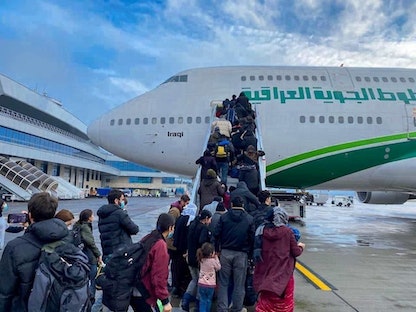 مهاجرون عراقيون يستقلون الطائرة في رحلة إجلاء في مطار مينسك، ببيلاروسيا. 18 نوفمبر 2021 - REUTERS