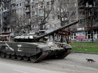 دبابة روسية في مدينة ماريوبل الساحلية بجوار مبان مدمرة - 19 إبريل 2022 - REUTERS