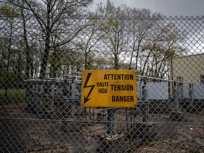 علامة تحذيرية تشير إلى خطر الإصابة بصدمة كهربائية في حال الاقتراب من السياج المحيط بأحد المنشآت في جنيف بسويسرا - AFP