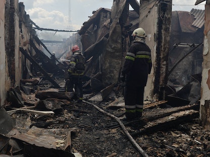 رجال الإطفاء يعملون في موقع كلية مهنية تضررت بشدة من ضربة صاروخية روسية في خاركوف الأوكرانية - 30 يوليو 2022. - REUTERS