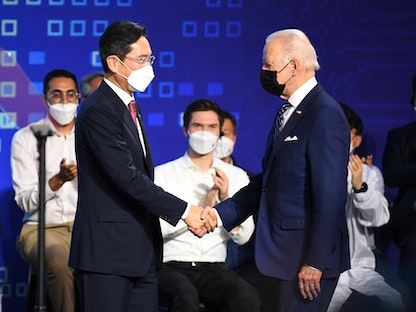 الرئيس الأميركي جو بايدن يصافح نائب رئيس شركة "سامسونج" لي يانج يونج بعد مؤتمر صحافي في مقر الشركة بسول - 20 مايو 2022 - REUTERS