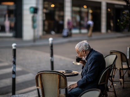 رجل يحتسي القهوة خارج أحد مقاهي العاصمة الفرنسية باريس - 2 يونيو 2020 - AFP