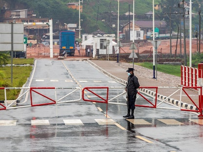 ضابط شرطة رواندي يقف حارساً عند حاجز نقطة حدودية واحدة في جاتونا في جيكومبي، شمال رواندا - 31 يناير 2022 - REUTERS