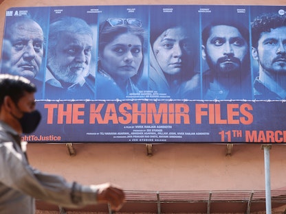 رجل يمر بجانب ملصق لفيلم "ملفات كشمير" خارج سينما في مومباي، الهند. 16 مارس 2022 - REUTERS