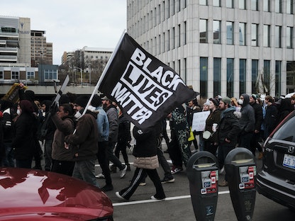  محتجون يحملون لافتة "حياة السود مهمة" في مدينة جراند رابيدز بولاية ميشيجان - 16 أبريل 2022. - AFP