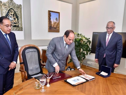 محافظ البنك المركزي طارق عامر (يميناً) يطلع الرئيس المصري عبد الفتاح السيسي على عينات من  العملات النقدية الجديدة بحضور رئيس مجلس الوزراء مصطفى مدبولي -31 يوليو 2021. - facebook/Egy.Pres.Spokesman