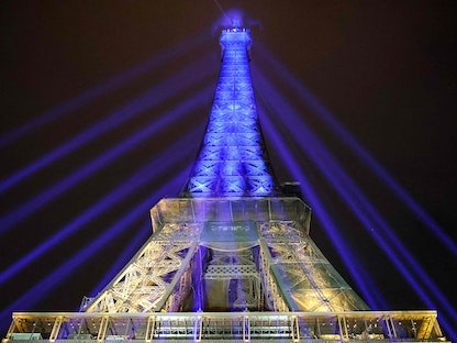 برج إيفل مضاء بلوني العلم الأوكراني لإظهار الدعم لكييف في الذكرى الأولى للغزو الروسي، باريس- 23 فبراير 2023 - AFP