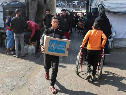 فلسطيني يحمل صندوق مساعدات وزعته وكالة "الأونروا" في دير البلح وسط قطاع غزة. 4 نوفمبر 2024 - REUTERS