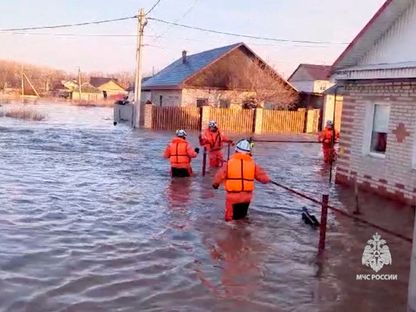 رجال الإنقاذ يشقون طريقهم إلى منطقة سكنية غمرتها الفيضانات بمدينة أورسك في روسيا. 6 أبريل 2024 - Reuters