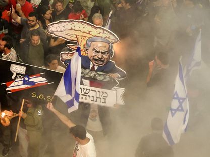 متظاهرون إسرائيليون يحملون صورة كاريكاتورية لرئيس الوزراء الإسرائيلي بنيامين نتنياهو كرجل غاضب خلال تظاهرة مناهضة لحكومته، تل أبيب. 6 أبريل 2024 - AFP