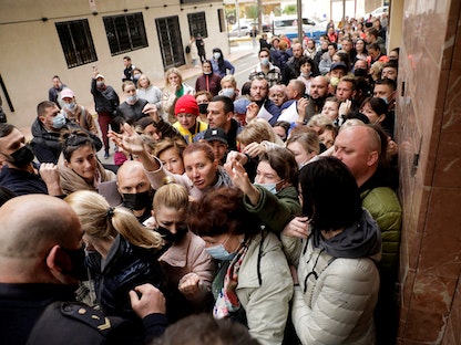 لاجئون أوكرانيون أمام مكتب توثيق للتقدم بطلب للحصول على الحماية المؤقتة التي وافق عليها الاتحاد الأوروبي والتي تسمح بالإقامة وتصريح العمل، في توريفايجا، إسبانيا- 15 مارس 2022. - REUTERS