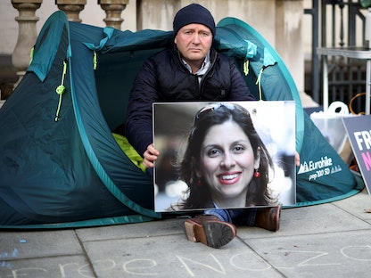 ريتشارد راتكليف، زوج البريطانية-الإيرانية نازانين زاغاري راتكليف، يحمل صورة زوجته خلال إضراب عن الطعام خارج مبنى وزارة الخارجية البريطانية في لندن - 25 أكتوبر 2021 - REUTERS