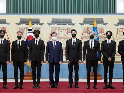 رئيس كوريا الجنوبية مون جاي إن يتوسط أعضاء فرقة BTS أثناء استلامهم جوازات سفر دبلوماسية لحضور جلسة للأمم المتحدة كمبعوثين رئاسيين خاصين لكوريا الجنوبية - AFP
