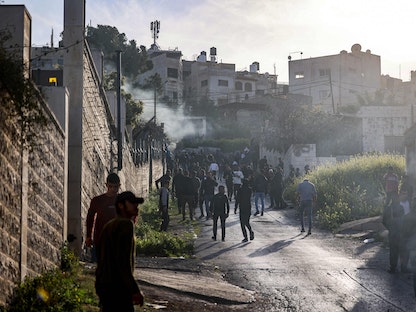 فلسطينيون يتجمعون على طول طريق خلال غارة إسرائيلية على مخيم جنين للاجئين في الضفة الغربية المحتلة. 7 مارس 2023 - AFP