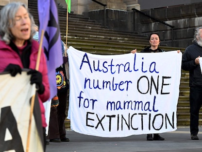 متظاهرون يحملون لافتات خارج برلمان ولاية فيكتوريا في ملبورن اعتراضاً على تزايد الانقراض – 19 يوليو 2022 - AFP