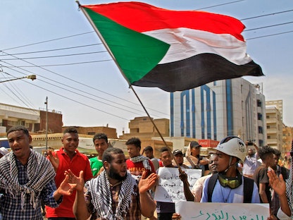 متظاهرون يحملون علم السودان خلال احتجاجات بالعاصمة الخرطوم. 13 سبتمر 2022 - AFP
