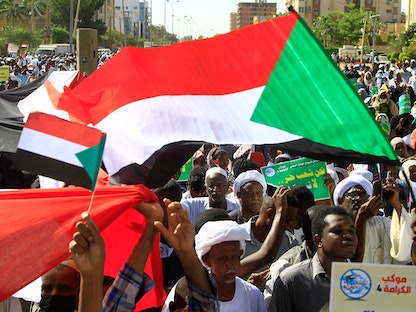 متظاهرون سودانيون يلوحون بالأعلام أثناء مظاهرة خارج بعثة الأمم المتحدة في العاصمة الخرطوم. 3 ديسمبر 2022 - AFP