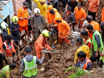 عمال الإنقاذ، يزيلون الأنقاض أثناء بحثهم عن ناجين بعد انهيار منزل سكني، بسبب انهيار أرضي ناجم عن هطول الأمطار الغزيرة في مومباي - REUTERS