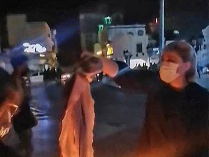 لقطة من مقطع فيديو تظهر سيدة تحرق غطاء رأسها خلال مظاهرة في بوشهر جنوب إيران - 25 سبتمبر 2022 - AFP