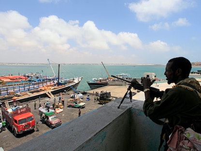 جندي يراقب الأنشطة في ميناء كيسمايو البحري في جوبالاند - REUTERS
