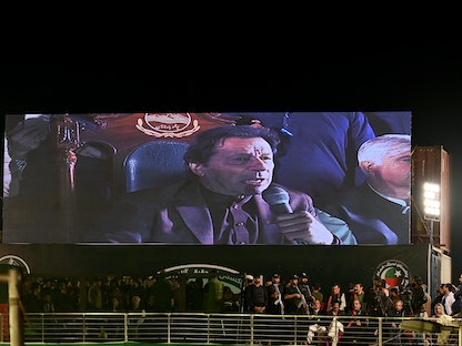 رئيس الوزراء الباكستاني السابق عمران خان على شاشة عملاقة وهو يخاطب أنصاره في تجمع حاشد بمدينة روالبندي - 26 نوفمبر 2022 - AFP