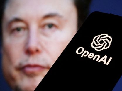 علامة شركة OpenAl التجارية تظهر على شاشة هاتف ذكي، وفي الخلفية تظهر صورة لوجه إيلون ماسك. 11 مارس 2024 - REUTERS