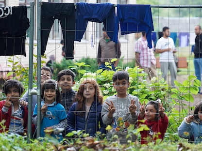 أطفال مهاجرون قرب سياج في مركز احتجاز مؤقت بليتوانيا - 12 أغسطس 2021 - REUTERS