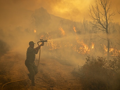 جانب من عمليات احتواء حرائق الغابات في منطقة العرائش شمالي المغرب - 15 يوليو 2022 - AFP