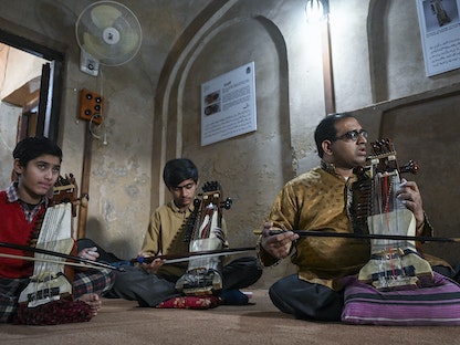  طلاب يتعلمون العزف على آلة السارانجي في إحدى أكاديميات لاهور - AFP
