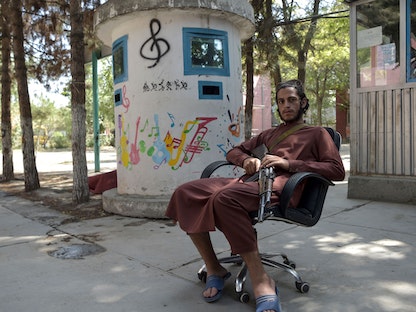 أحد مقاتلي حركة طالبان يجلس في فناء المعهد الوطني الأفغاني للموسيقى بكابول- 14 سبتمبر 2021 - AFP