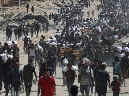فلسطينيون يحملون مساعدات غذائية في بيت لاهيا، شمال قطاع غزة. 27 يوليو 2025 - REUTERS