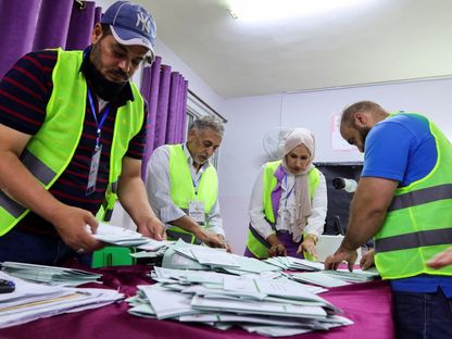 عاملون يقومون بفرز الأصوات داخل مركز اقتراع عقب انتهاء التصويت في الانتخابات البرلمانية بالعاصمة الأردنية عمّان. 10 سبتمبر 2024 - Reuters