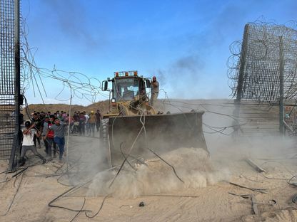 فلسطينيون يقتحمون الجانب الإسرائيلي من السياج الحدودي بين إسرائيل وغزة بعد أن تسلل مقاتلون إلى مناطق جنوب إسرائيل. 7 أكتوبر 2023 - Reuters