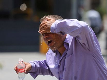 سائق تاكسي إيراني يرش الماء على نفسه خلال موجة الحر في طهران. إيران في 21 يوليو 2024 - reuters