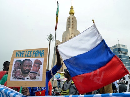 ماليون يحملون صورة زعيم الانقلاب العقيد أسيمي غويتا، والعلم الروسي خلال مظاهرة في باماكو، مالي. 28 مايو 2021 - REUTERS