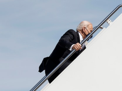 الرئيس الأميركي جو بايدن وهو يحاول الوقوف بعد تعثره خلال صعود الطائرة الرئاسية متوجهاً إلى أتلانتا-19 مارس 2021 - REUTERS