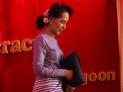 زعيمة المعارضة في ميانمار ورئيسة الرابطة الوطنية من أجل الديمقراطية أونج سان سو تشي تغادر المسرح بعد إلقاء كلمة في مؤتمر صحافي من مجمعها السكني في يانجون- 5 نوفمبر 2015 - AFP