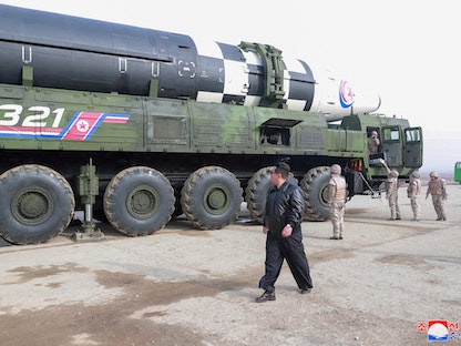 زعيم كوريا الشمالية كيم جونج أون يسير بجوار الصاروخ الباليستي العابر للقارات "هواسونج-17" على مركبة الإطلاق- 25 مارس 2022 - REUTERS