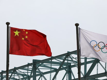 علم الصين يرفرف بجانب العلم الأولمبي في اللجنة المنظمة لدورة الألعاب الأولمبية الشتوية لعام 2022 - بكين - REUTERS