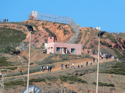 مهاجرون يتجهون نحو السياج الفاصل بين المغرب وإسبانيا في سبتة-19 مايو 2021 - REUTERS